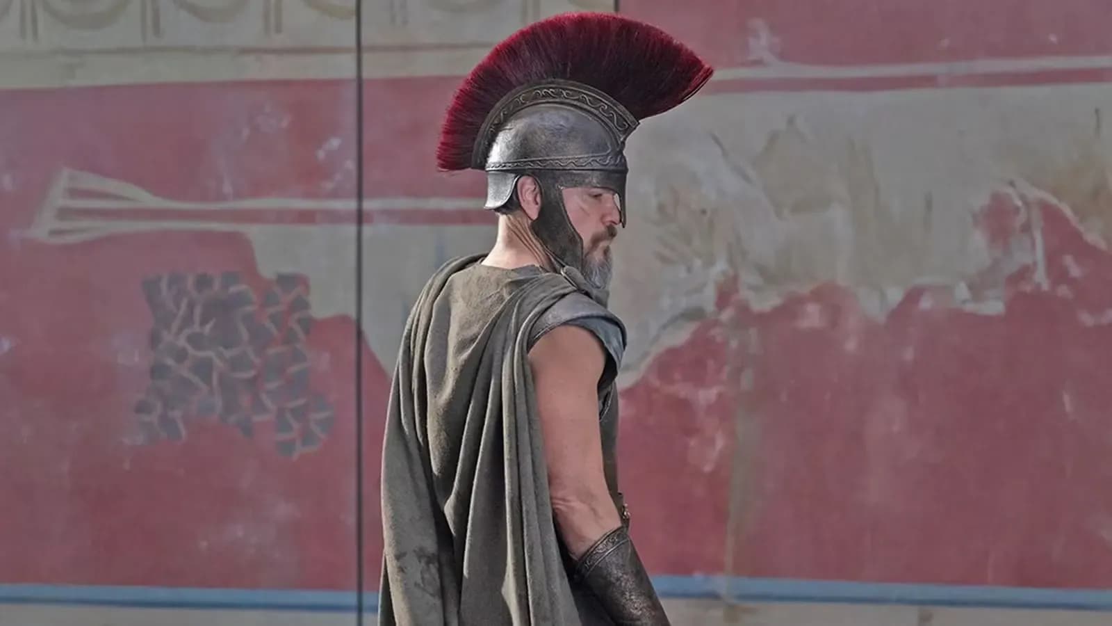 Matt Damon as Odysseus in the first official image released from Christopher Nolan's The Odyssey, wearing ancient Greek armor and a Corinthian-style helmet.